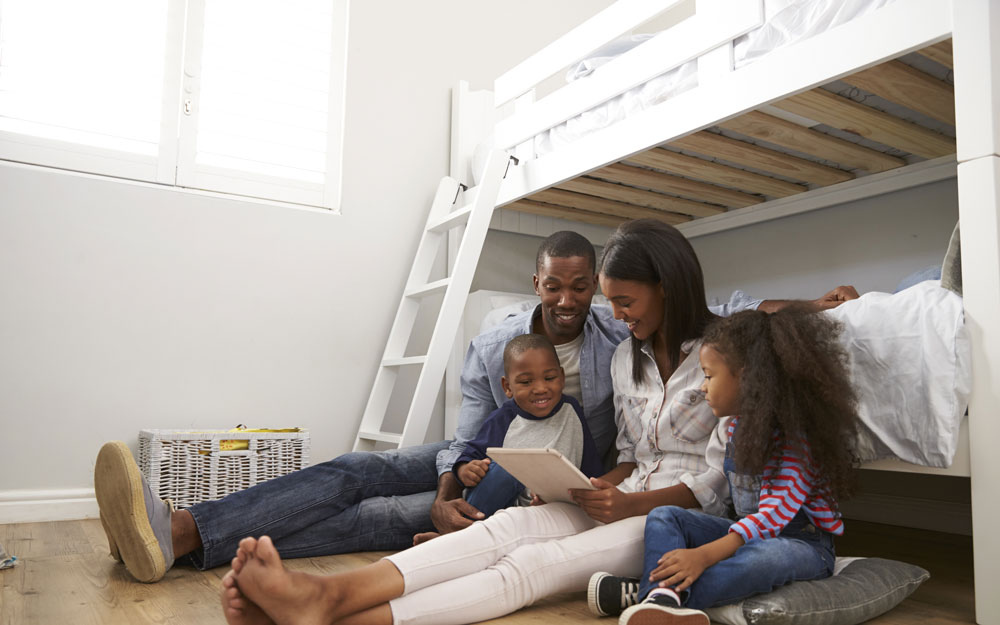 Family reading a story near to the bunk bed