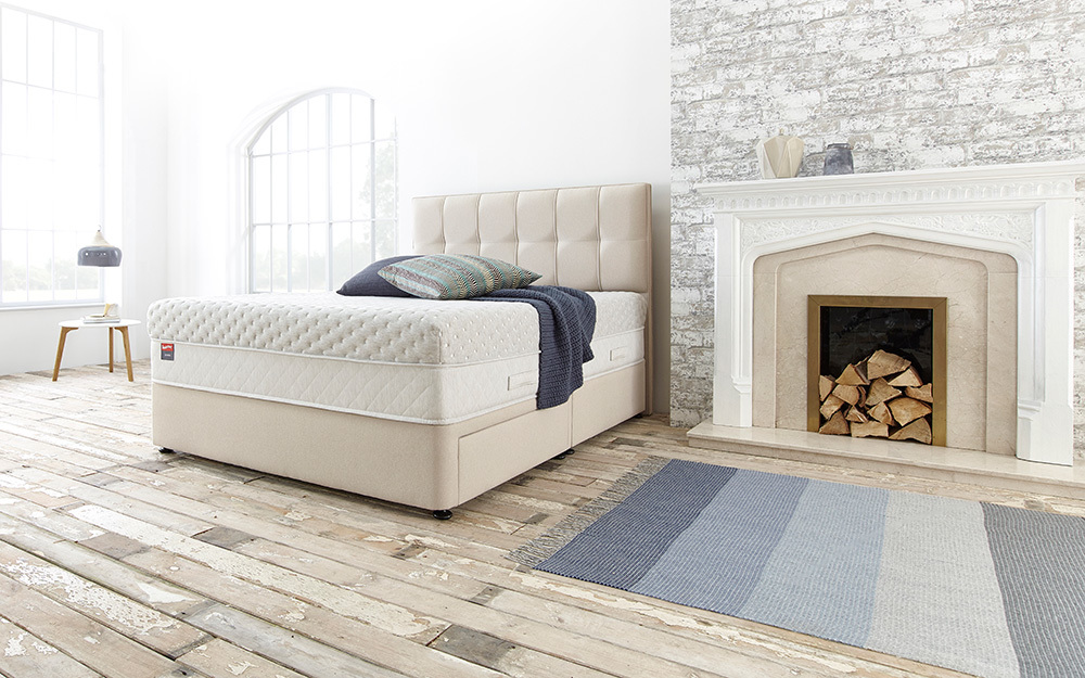 The Slumberland Serene 3300 Pocket Divan Bed in a bedroom with two drawers