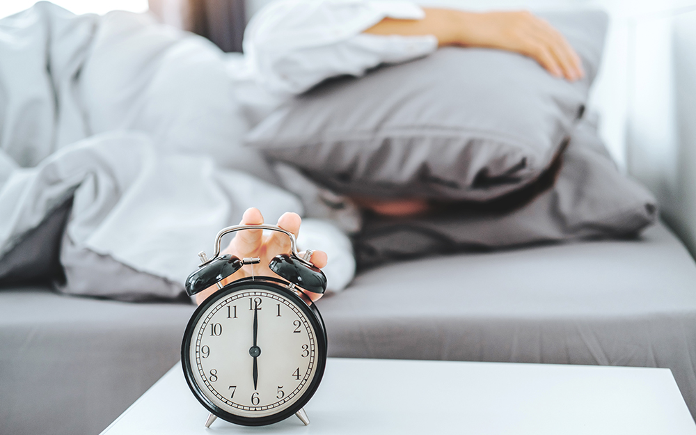 Person in bed trying not to look at alarm clock