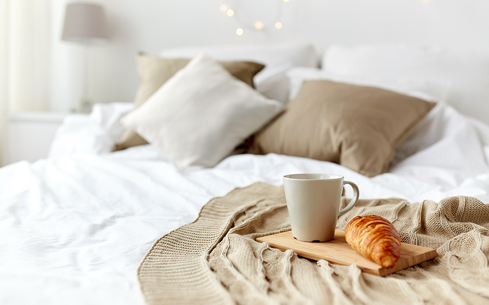 Croissant and tea on bed