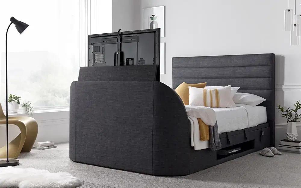 The Novo Aporo TV Ottoman Bed Frame in a cosy white bedroom with yellow furniture accents.