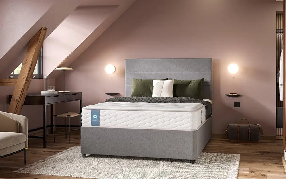 The Sealy Tudor Contract Mattress in a simple, yet elegant hoetl room with lilac walls.